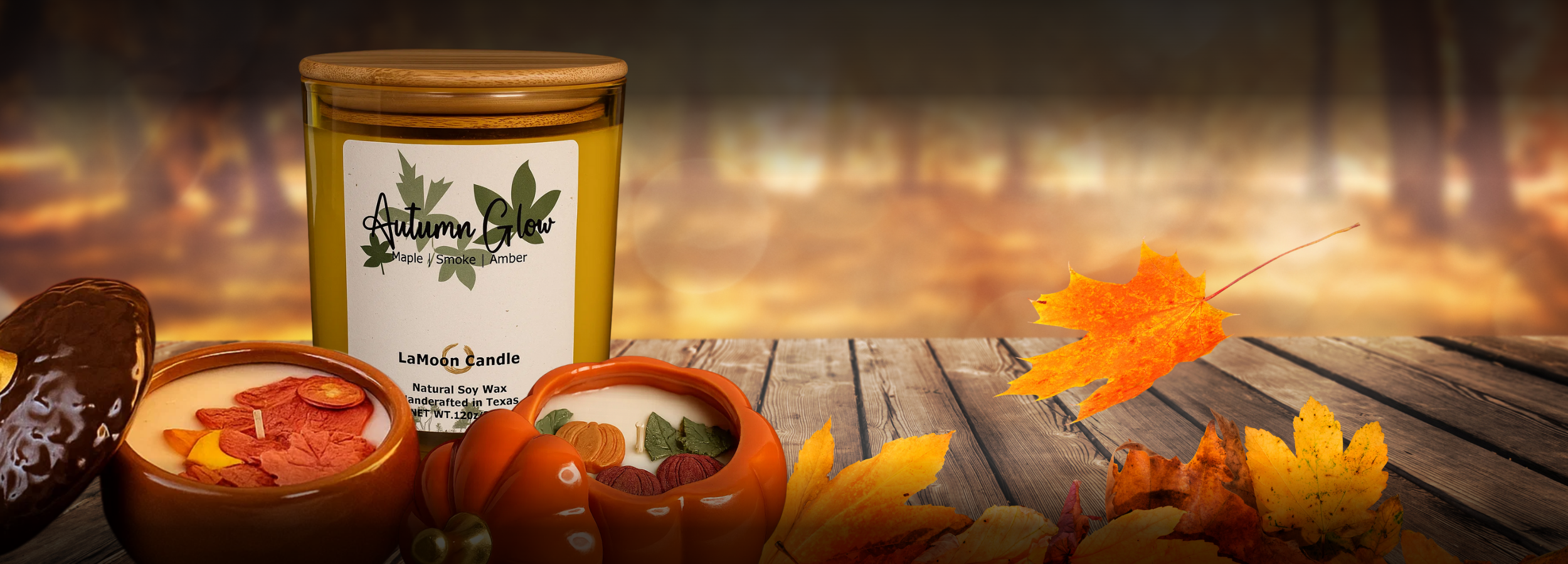 Lit soy candles on a rustic wood table with pumpkins and warm amber light, representing LaMoon Candle’s Gather and Glow Fall Collection.