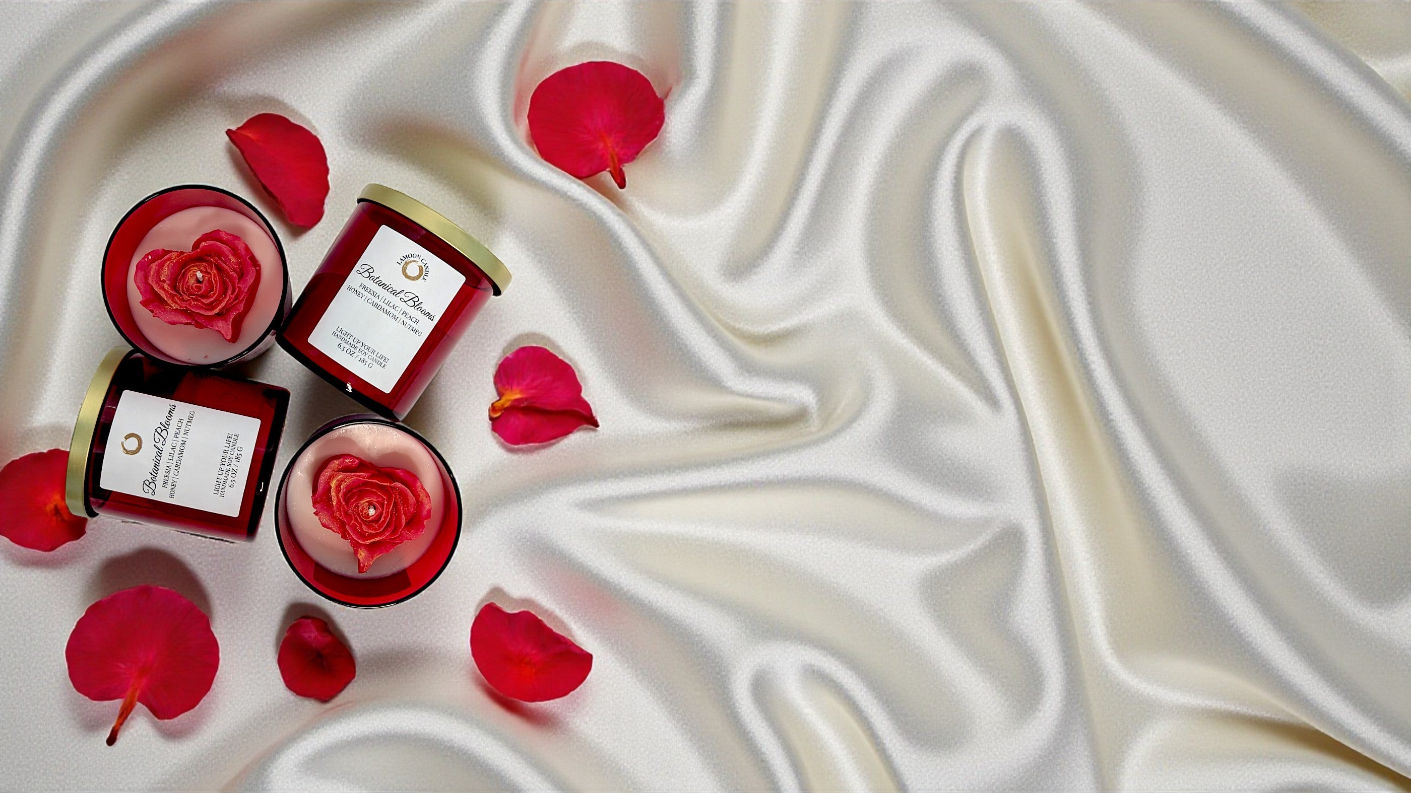 Red candles with rose petals on a white satin surface. Botanical Blooms scented Soy Candle - LaMoon Candle