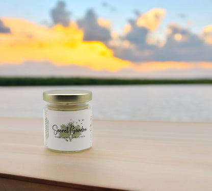 Natural soy wax candle in clear glass container and twist gold lid.