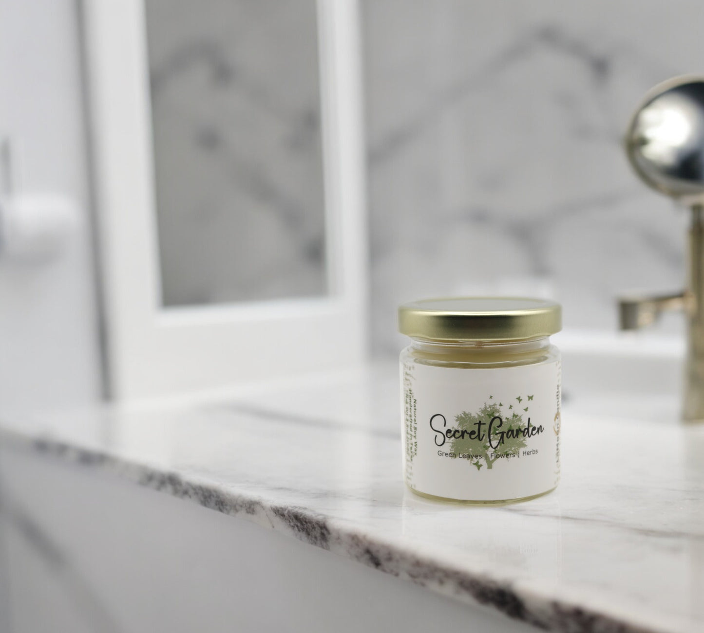 Natural soy wax candle in clear glass container and twist gold lid.