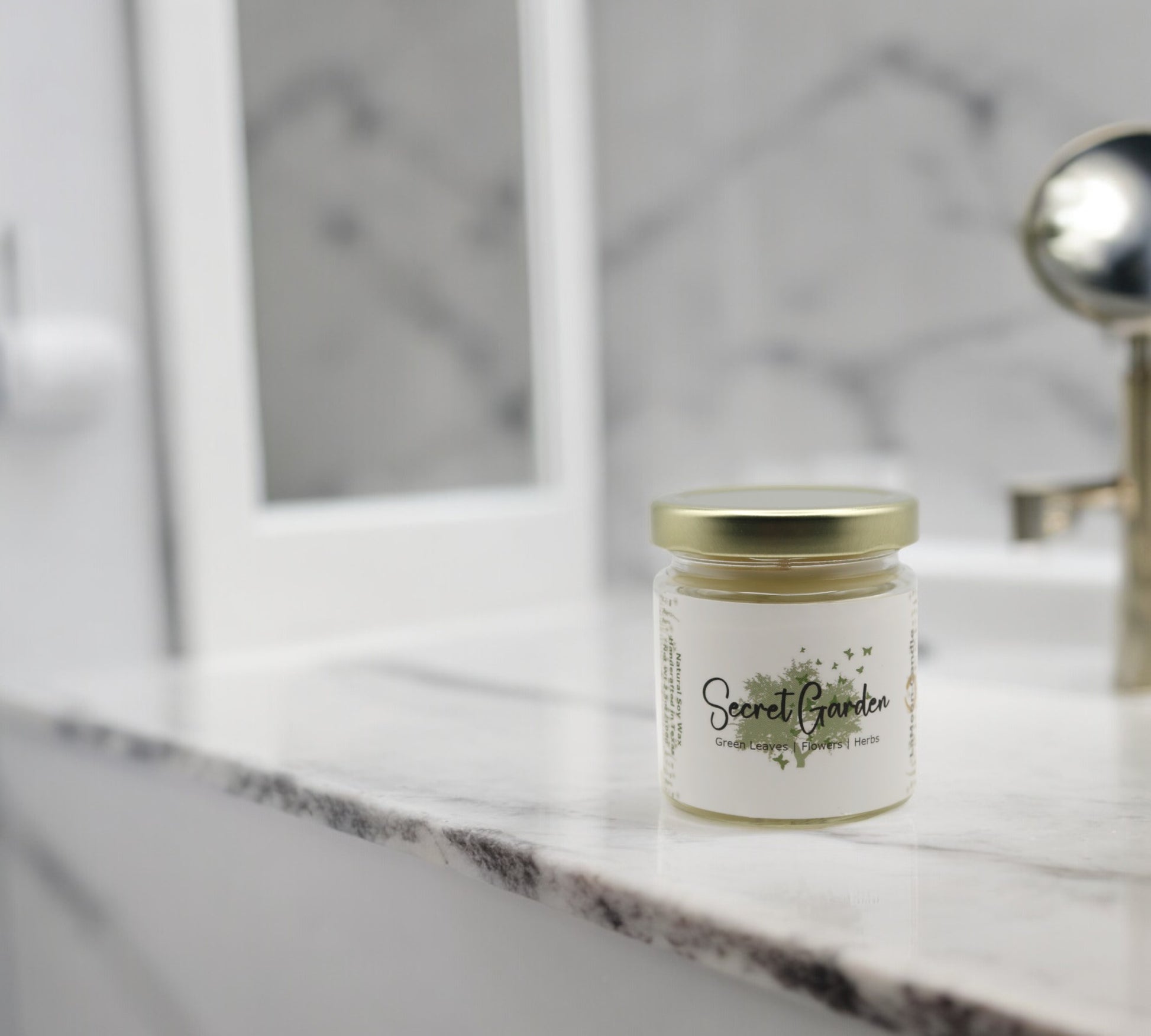 Natural soy wax candle in clear glass container and twist gold lid.