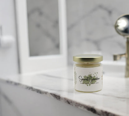Natural soy wax candle in clear glass container and twist gold lid.
