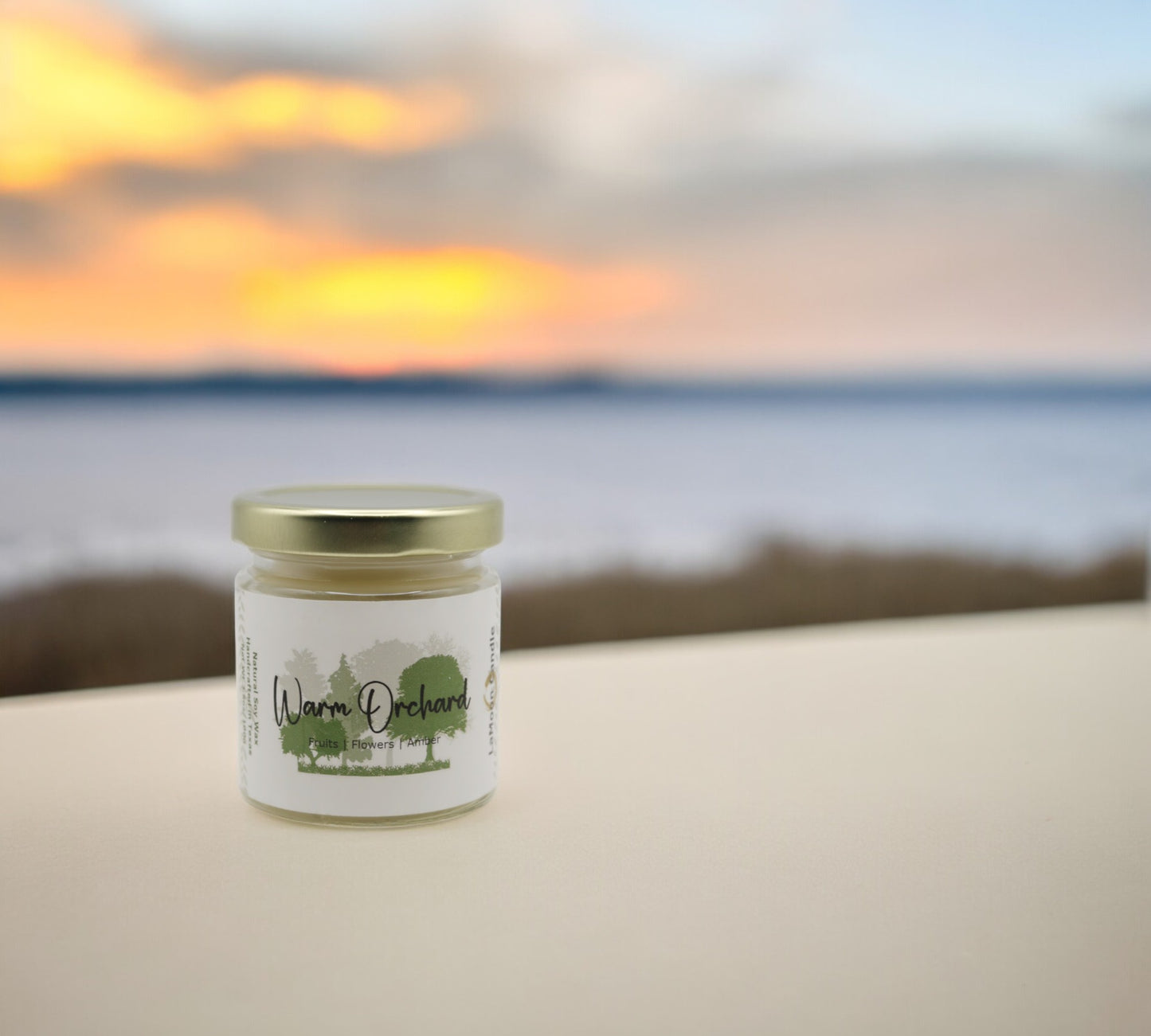 Natural soy wax candle in clear glass container and twist gold lid.