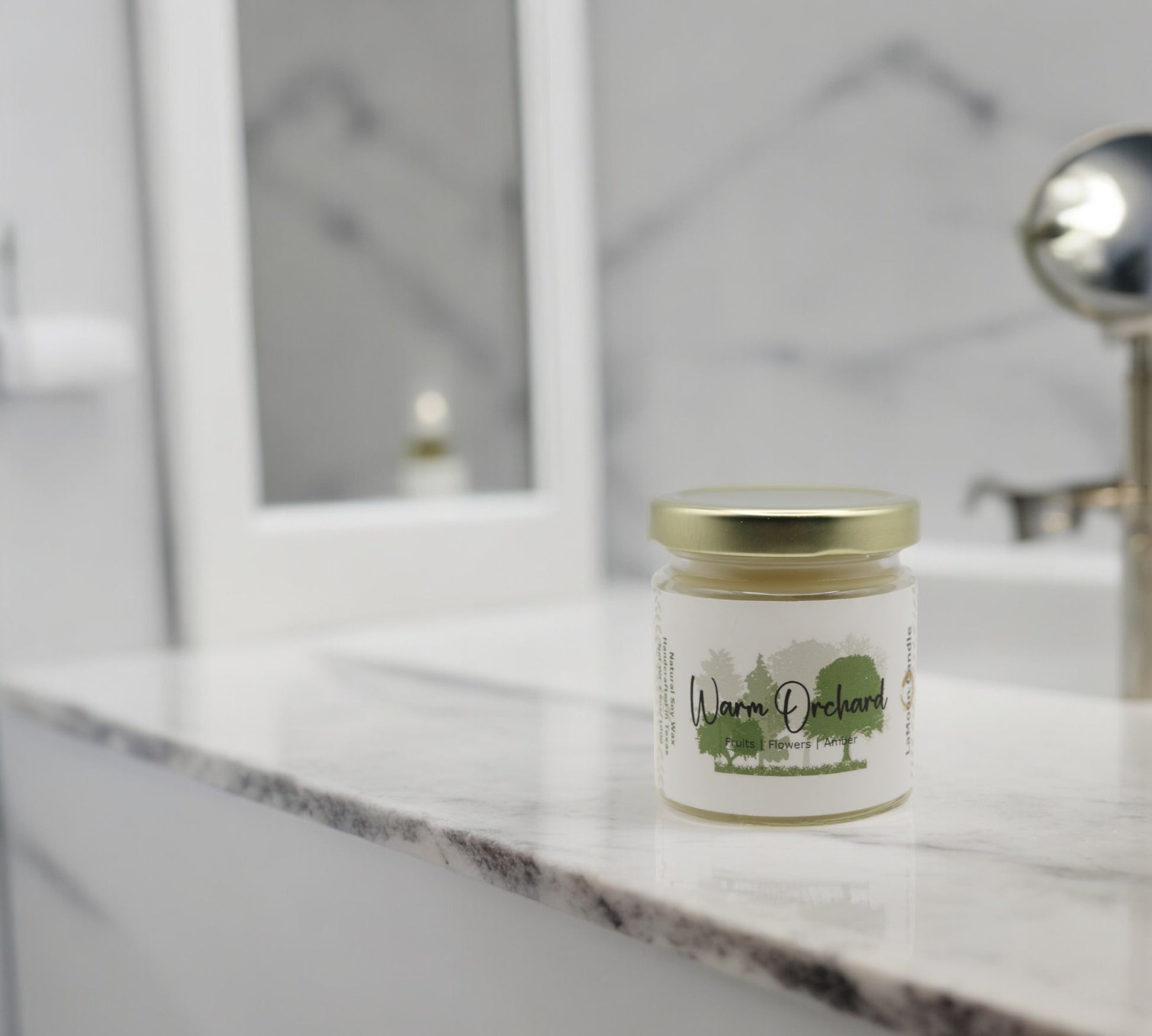 Natural soy wax candle in clear glass container and twist gold lid.